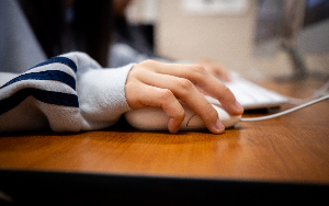   Student's hand on a computer mouse